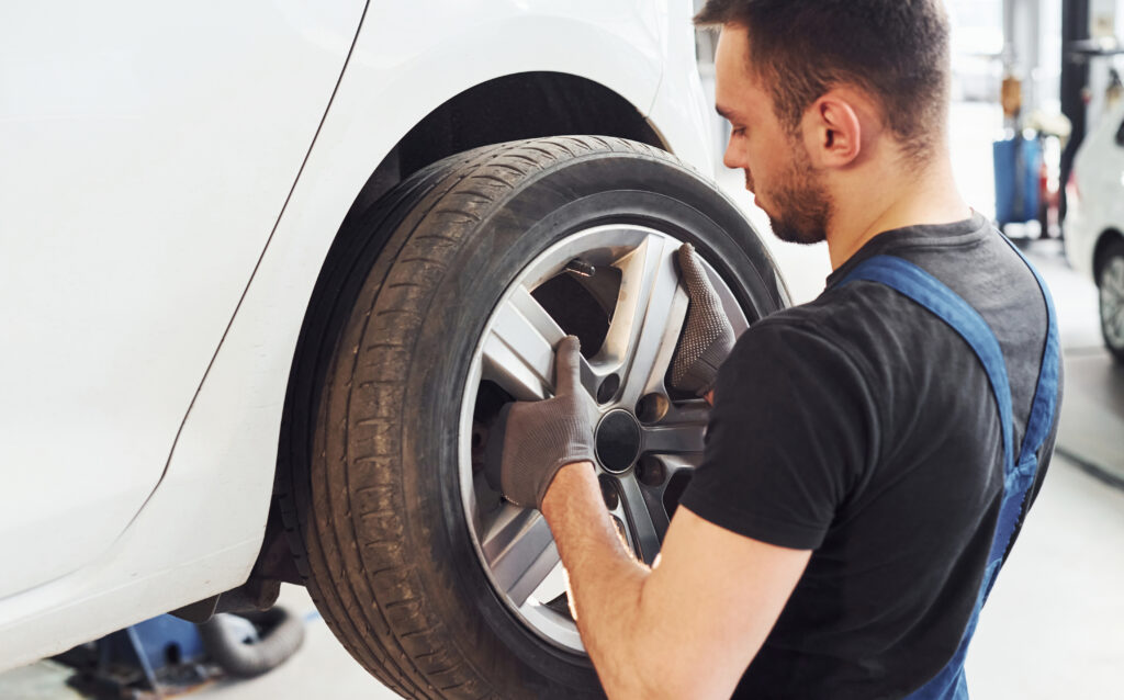 man in work uniform changing car wheel indoors co 2025 03 18 20 01 29 utc